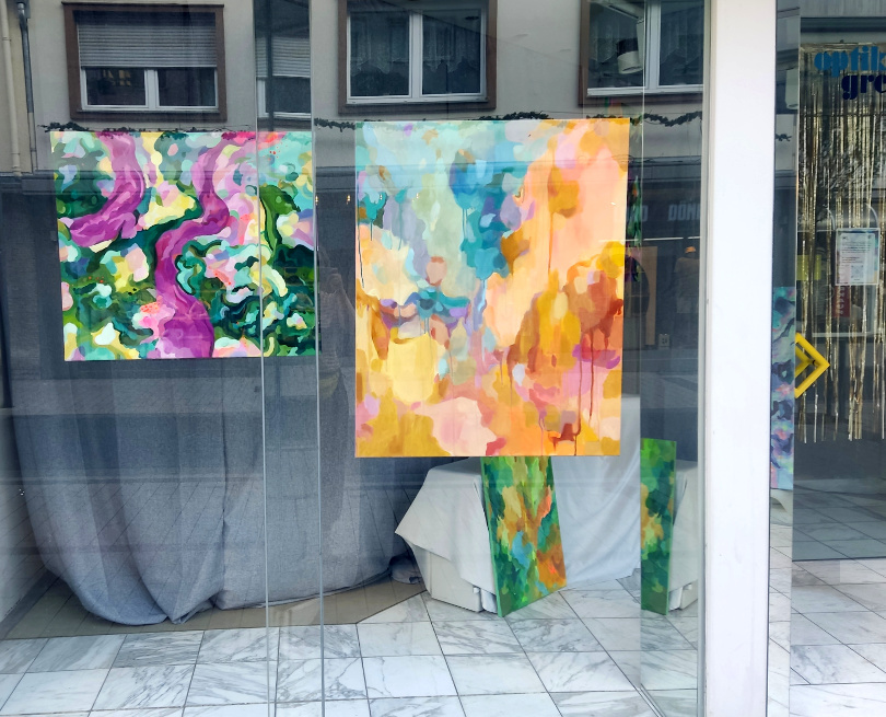 Abstrakte Ölgemälde mit den Titeln Lush und Summer Heat von der Künstlerin Vleo wird in einem Schaufenster asugestellt